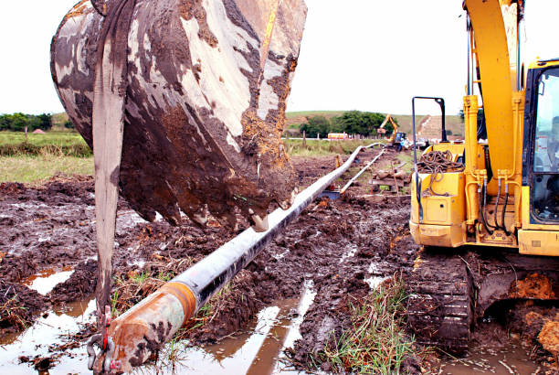 istock Excavator Holding Pipeline on Swamp 1151878069