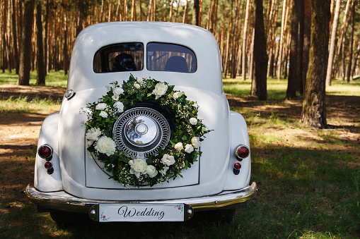 Wedding car with a decoration in the form of a wreath and the word 