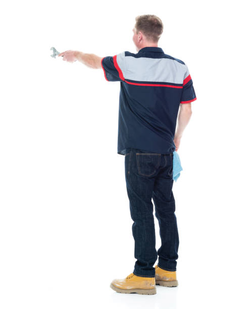 istock Young handsome male mechanic standing on white background - pointing 1151880099
