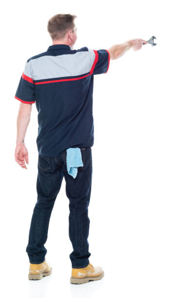 istock Young handsome male mechanic standing on white background - pointing 1151880101
