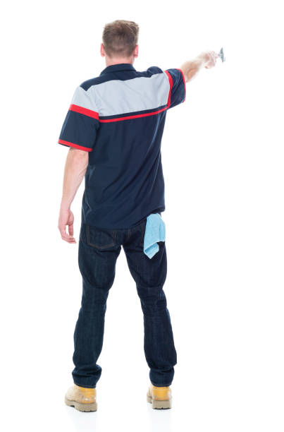 istock Young handsome male mechanic standing on white background - pointing 1151880103