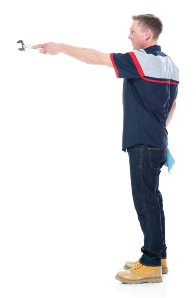 istock Young handsome male mechanic standing on white background - pointing 1151880106