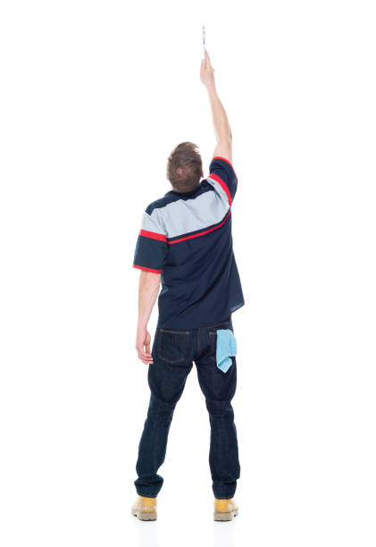 istock Young handsome male mechanic standing on white background - pointing up 1151880127