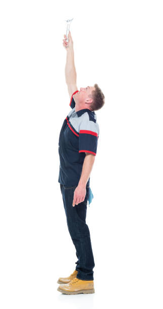 istock Young handsome male mechanic standing on white background - pointing up 1151880130