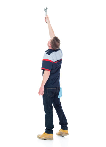 istock Young handsome male mechanic standing on white background - pointing up 1151880133