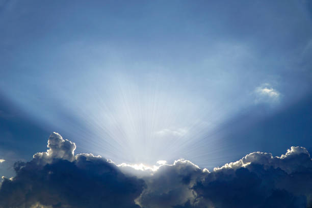 istock Beautiful blue sky with sunrays rising from behind clouds 1151880185