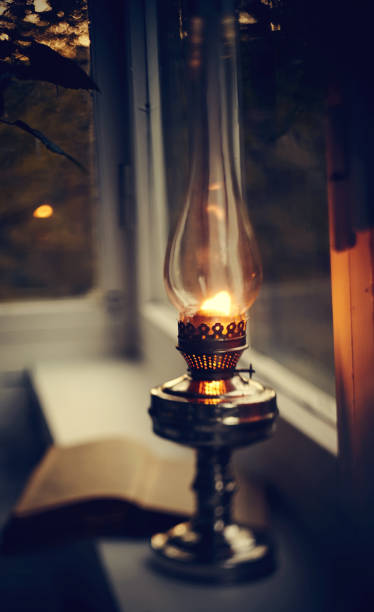 istock Vintage kerosene lamp burning and open book 1151880222