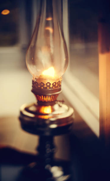 istock Vintage kerosene lamp burning and open book 1151880307