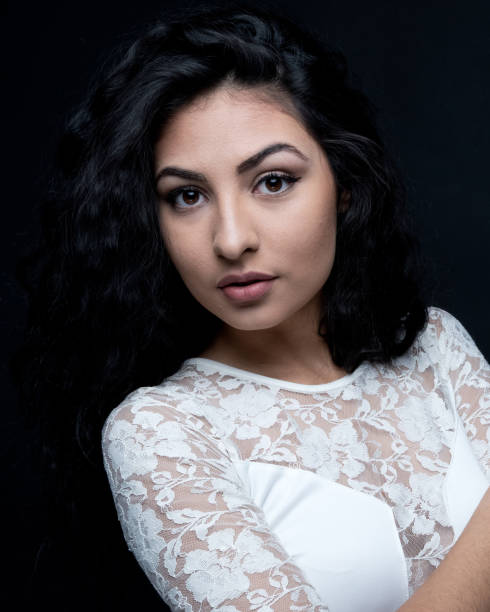 istock Good looking female with curly hair on black background 1151886112