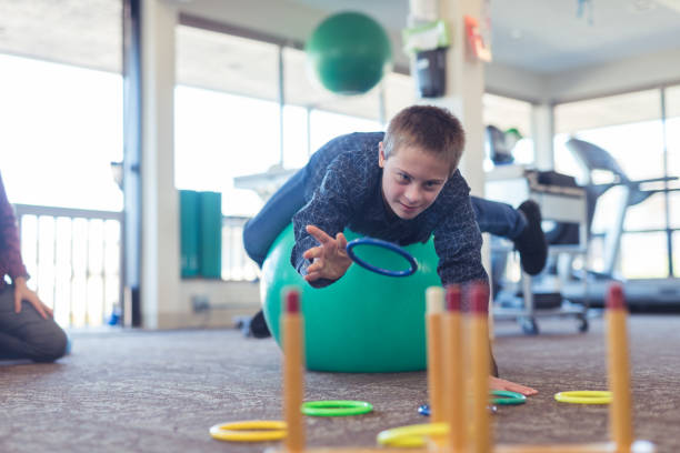 A boy does workouts with an occupational therapist at a physiotherapy clinic