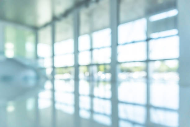 istock Office building lobby hall blur background or blurry school hallway corridor interior view looking toward empty entrance, glass curtain wall and floor with exterior light illumination 1151887756