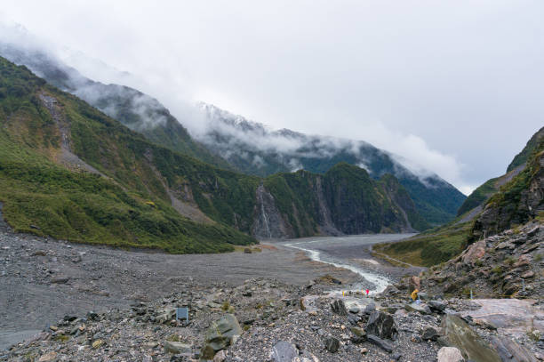 пейзаж долины ледника фокс с низкими облаками - glacier west coast south island new zealand people стоковые фото и изображения