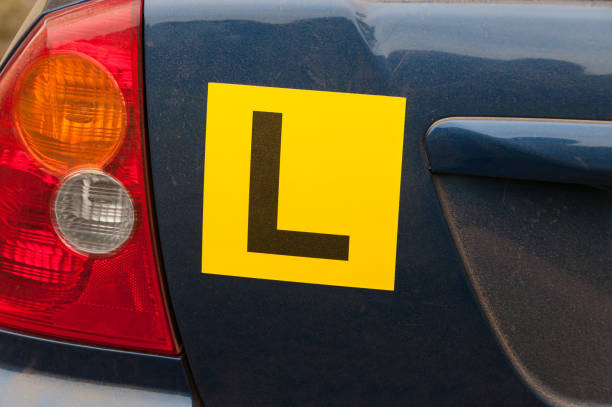 istock Yellow learner license plates on a back of blue car 1151887806