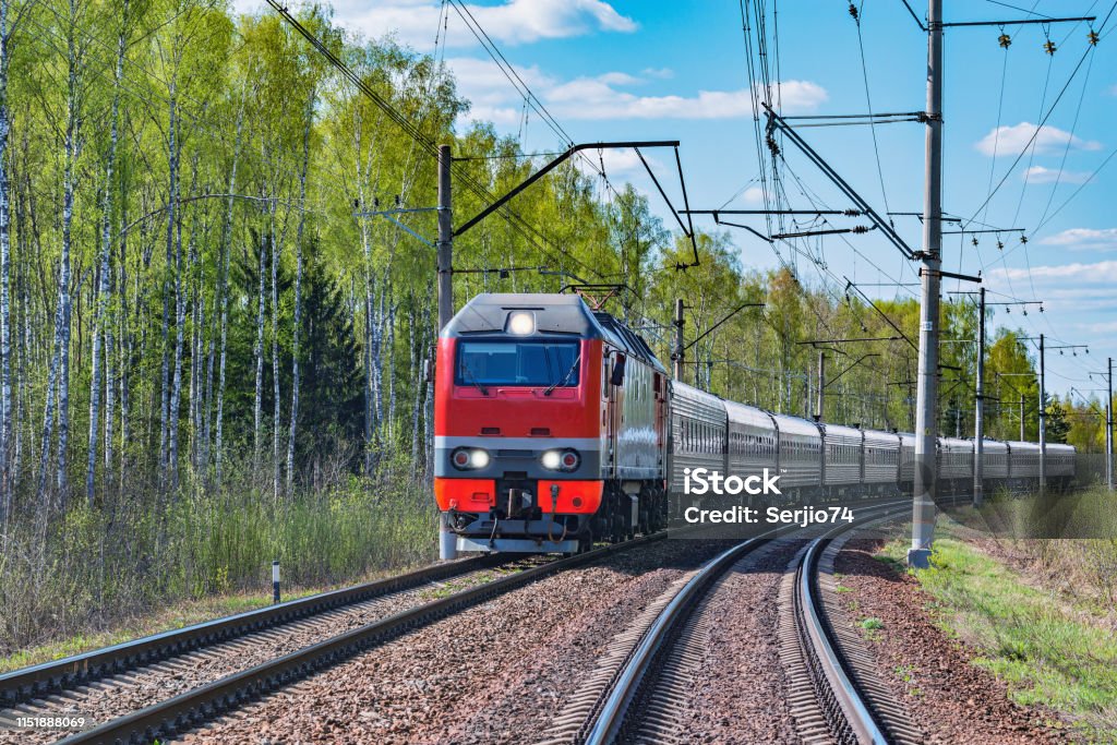 Passenger train approaches to the station. Passenger train approaches to the station at spring day time. Train - Vehicle Stock Photo