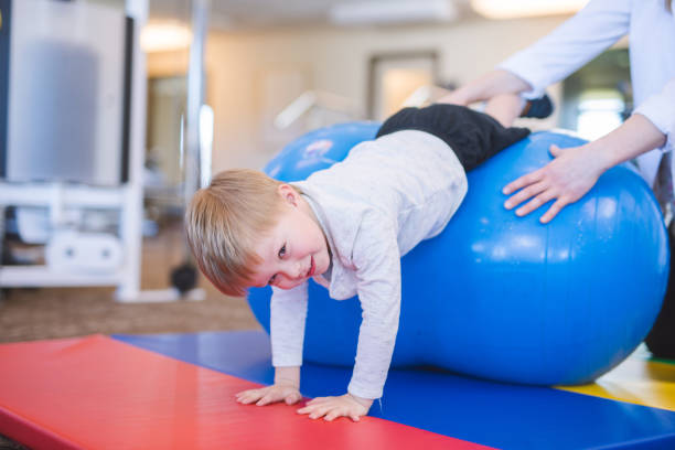 istock Physical therapist working with a young boy in the clinic 1151889705