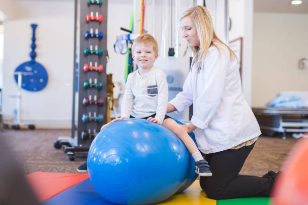 istock Young boy working with a physical therapist at a clinic 1151889706