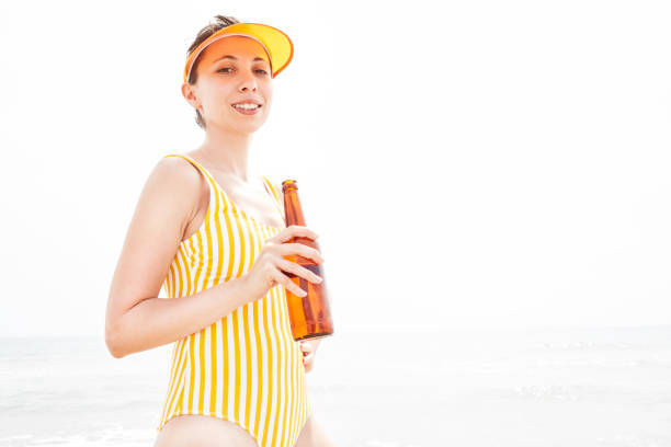 istock Woman Drinking Beer on the Beach 1151893030