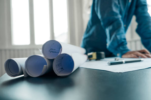 istock blueprint and tools on the table behind engineers using laptop to drawing design building Project in office, construction concept. Engineer concept 1151895321