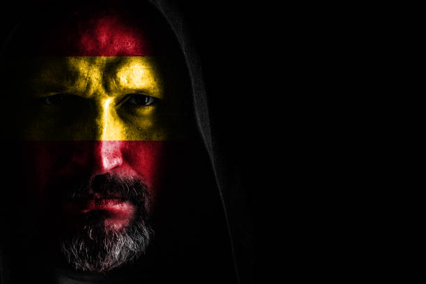 istock Brutal man with a gray beard in the hood with sharp shadows on a black background. Copy space. 1151898008