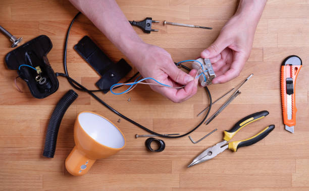 istock Man fixing desk lamp wires top view 1151906523