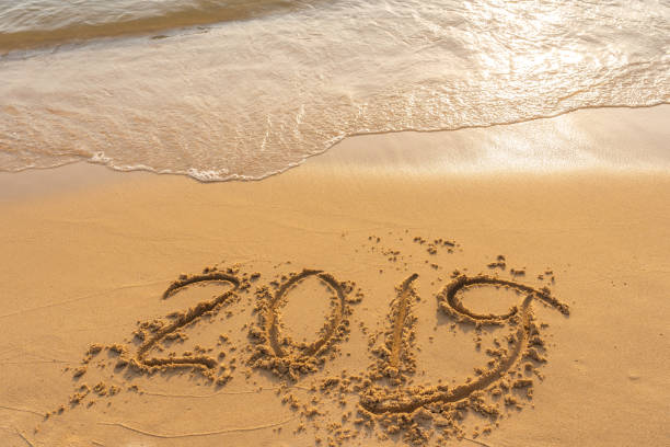 istock New year 2019 on sandy beach with waves 1151915136