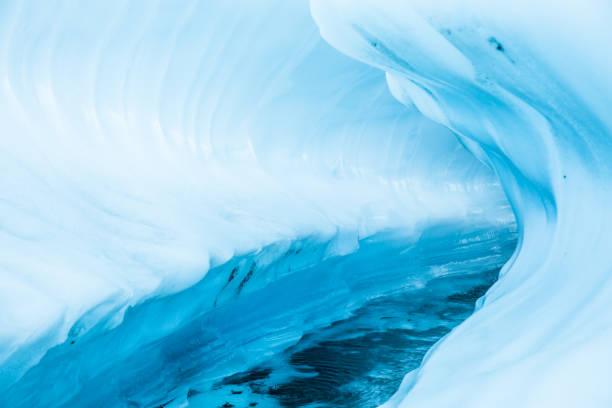 istock Ice canyon through a glacier in remote Alaska. Melting glacier river cuts through the surface creating overhanging ice. 1151917015