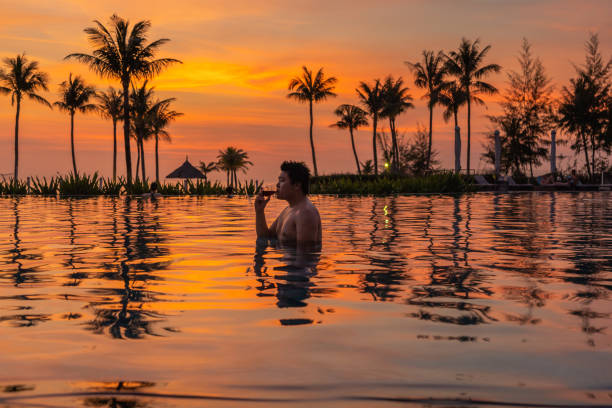 istock Asian man drinking red wine in luxury resort at sunset 1151919733