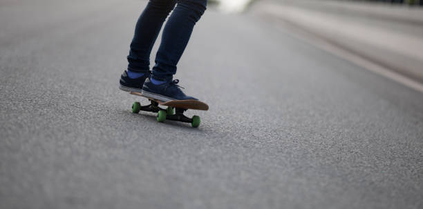 istock Skateboarder legs skateboarding on city road 1151921542