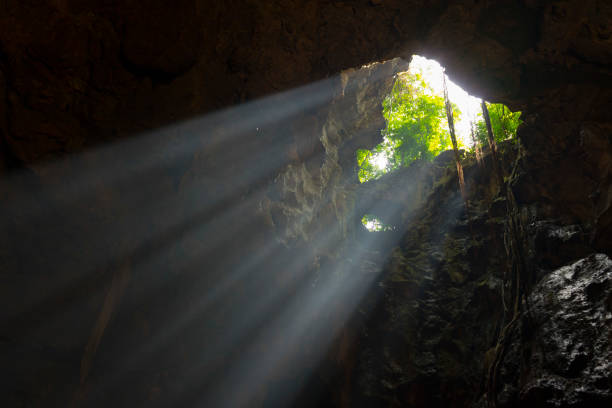 istock Sunlight burst from top of underground cave. 1151922636