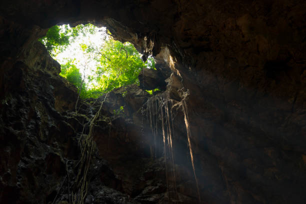 istock Sunlight burst from top of underground cave. 1151922638
