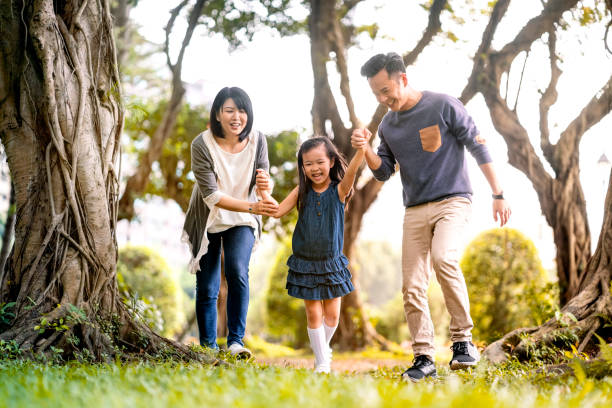istock Parents playing with cheerful daughter on grass 1151925767