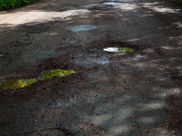 istock large pits with stones on the asphalt road 1151931395
