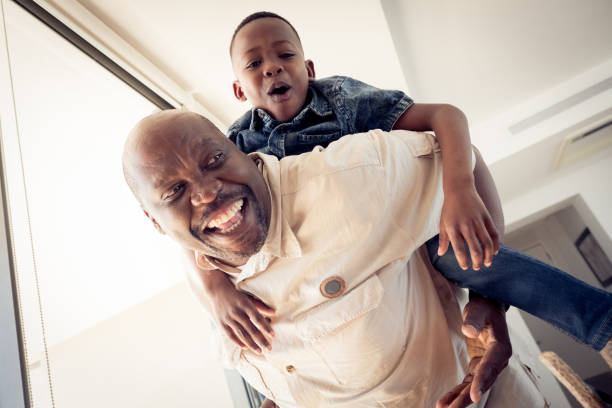 istock Low angle view of grandfather piggybacking boy 1151932253