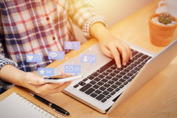 istock people using smartphone for social media interactions with notification icons from friend in social network with like, message, email, mention and star above smartphone screen. internet marketing 1151933944