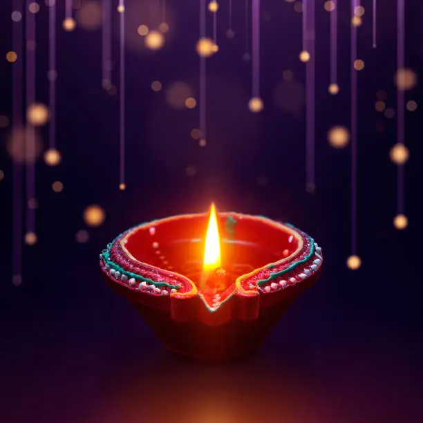 Photo of Diya oil lamp with hanging light background, Diwali celebration