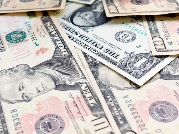 istock background from scattered dollar banknotes as abstract seamless. 1151934817