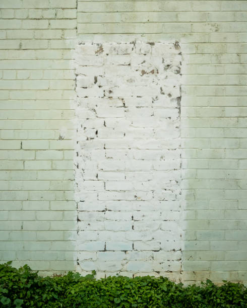 istock Badly painted bricked in doorway in light green brick wall 1151936328
