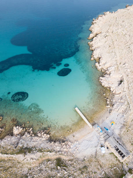 istock Turquoise colored bay with a pier from above 1151936706