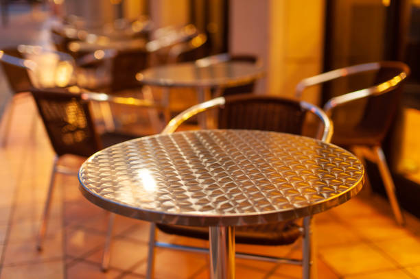 istock Orange table and chairs illuminated by streetlights 1151941202