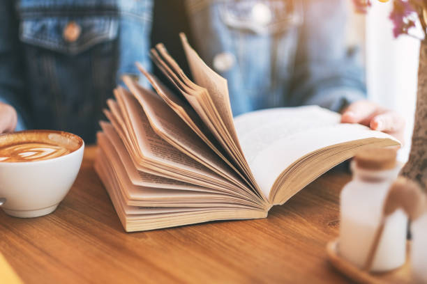 istock a woman holding and reading a vintage novel book 1151945868