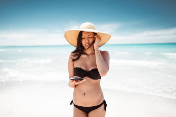 istock on the phone at summer on the beach 1151947188