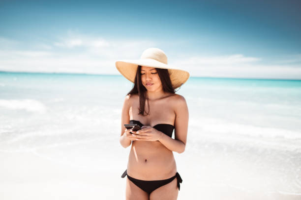 istock on the phone at summer on the beach 1151947237