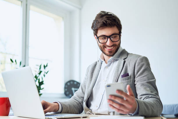istock Young businessman checking phone while working in home office 1151947770