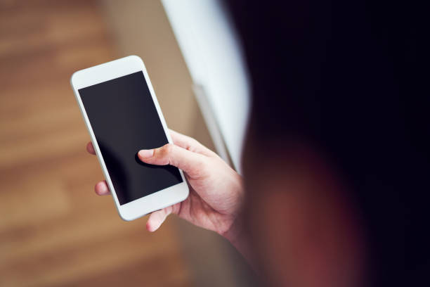 istock Close-up of man using smartphone indoors 1151947855