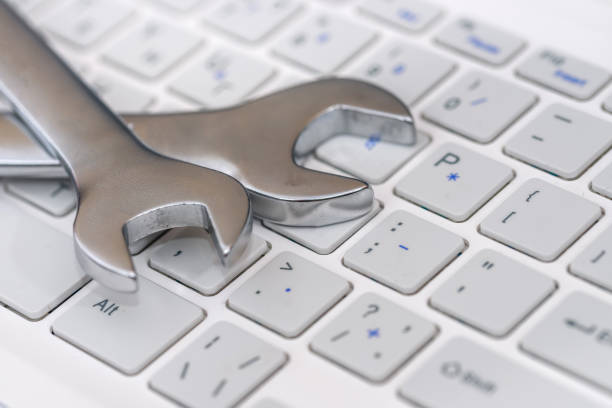 istock Notebook keyboard with steel spanners on it close up 1151948401