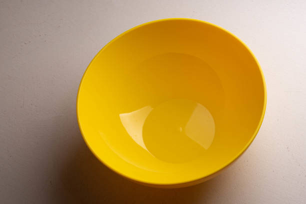 istock A yellow salad bowl with water drops on the wall is on the table. 1151954337