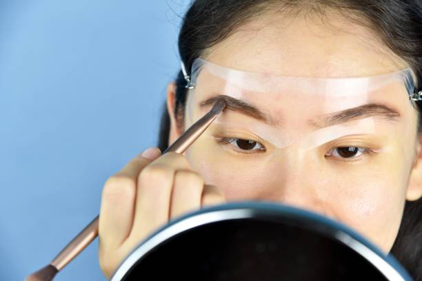 istock Eyebrows shaping makeup template, Asian women filling eyebrows to look thicker, Learning doing self makeup. 1151957500