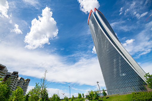 Milan, Italy - April 28, 2019: The modern architecture of the new City Life area. The area consists in a large park with a shopping district and three towers skyscrapers: the Hadid Tower (or Generali Tower), the Isozaki Tower (or Allianz Tower) and the Libeskind Tower (not yet completed).