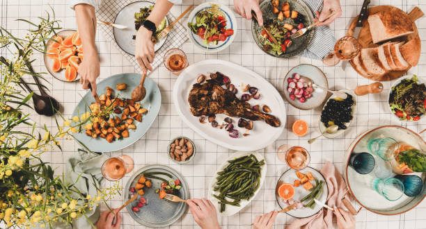 istock Peoples hands over table with meat, salads, wine, wide composition 1151959949