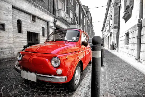 Red fiat 500 old vintage car in italy on a black and white background color splash postcard like photo